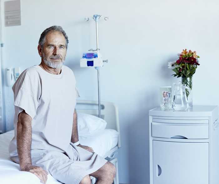 Patient sitzt in auf dem Krankenhausbett Patient sitzt in auf dem Krankenhausbett