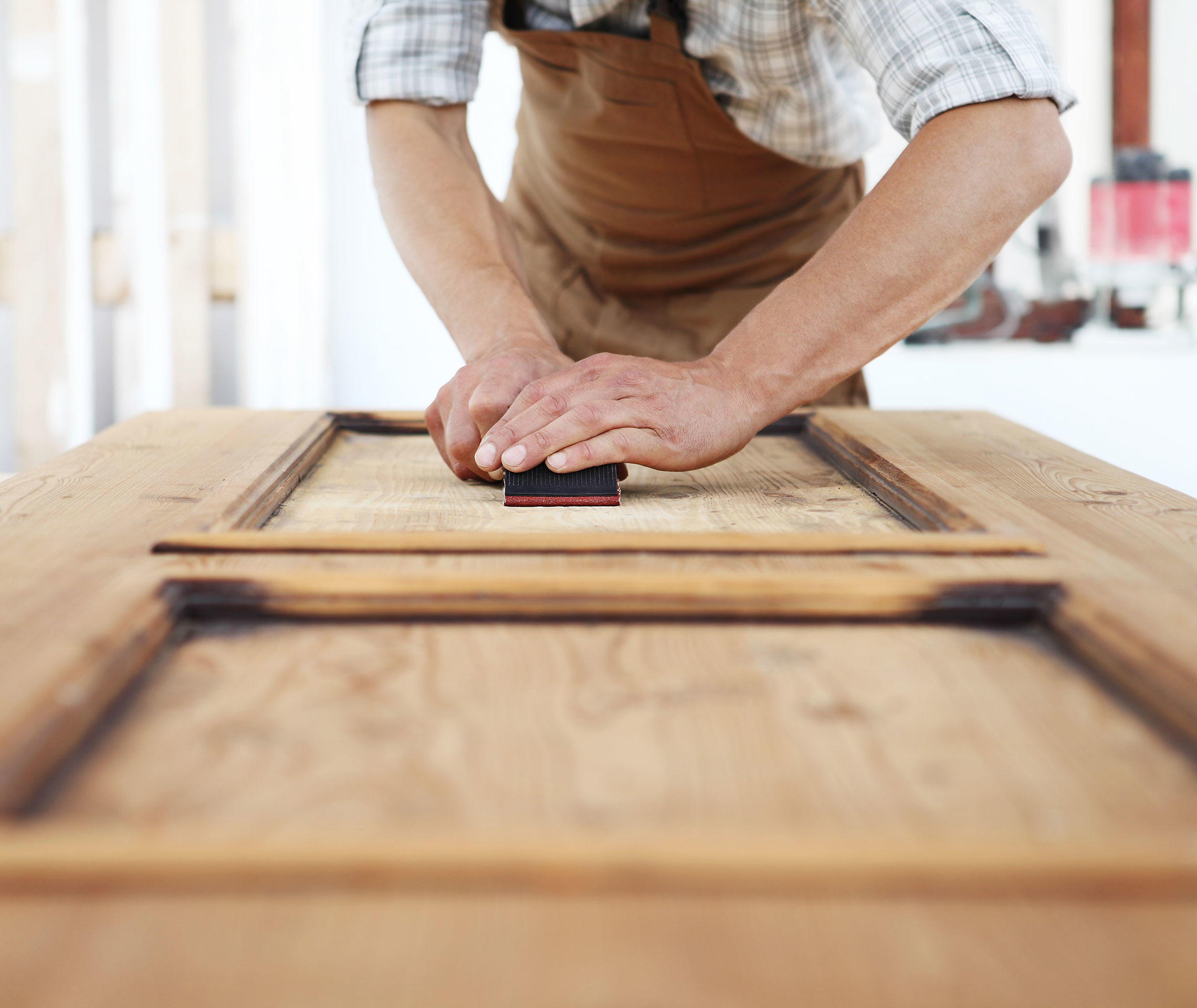 Handwerker schleift Holz.