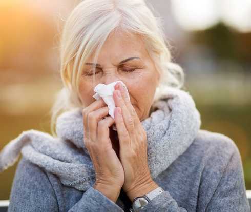 Eine Frau schnäuzt sich die Nase