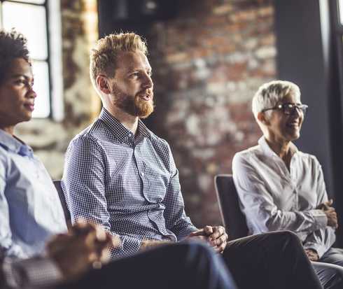 Drei Personen sitzen nebeneinander 