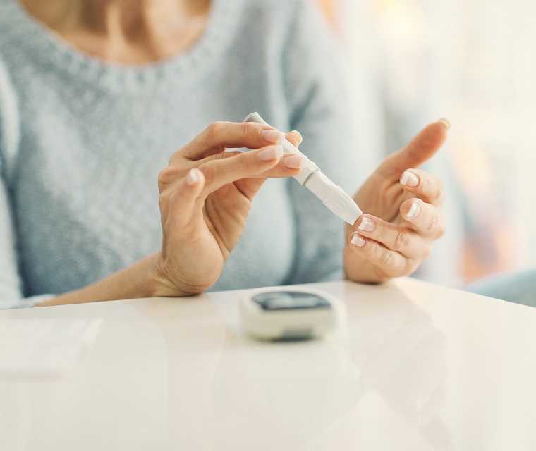 Foto von der Blutzuckermessung mit Stechhilfe am Finger